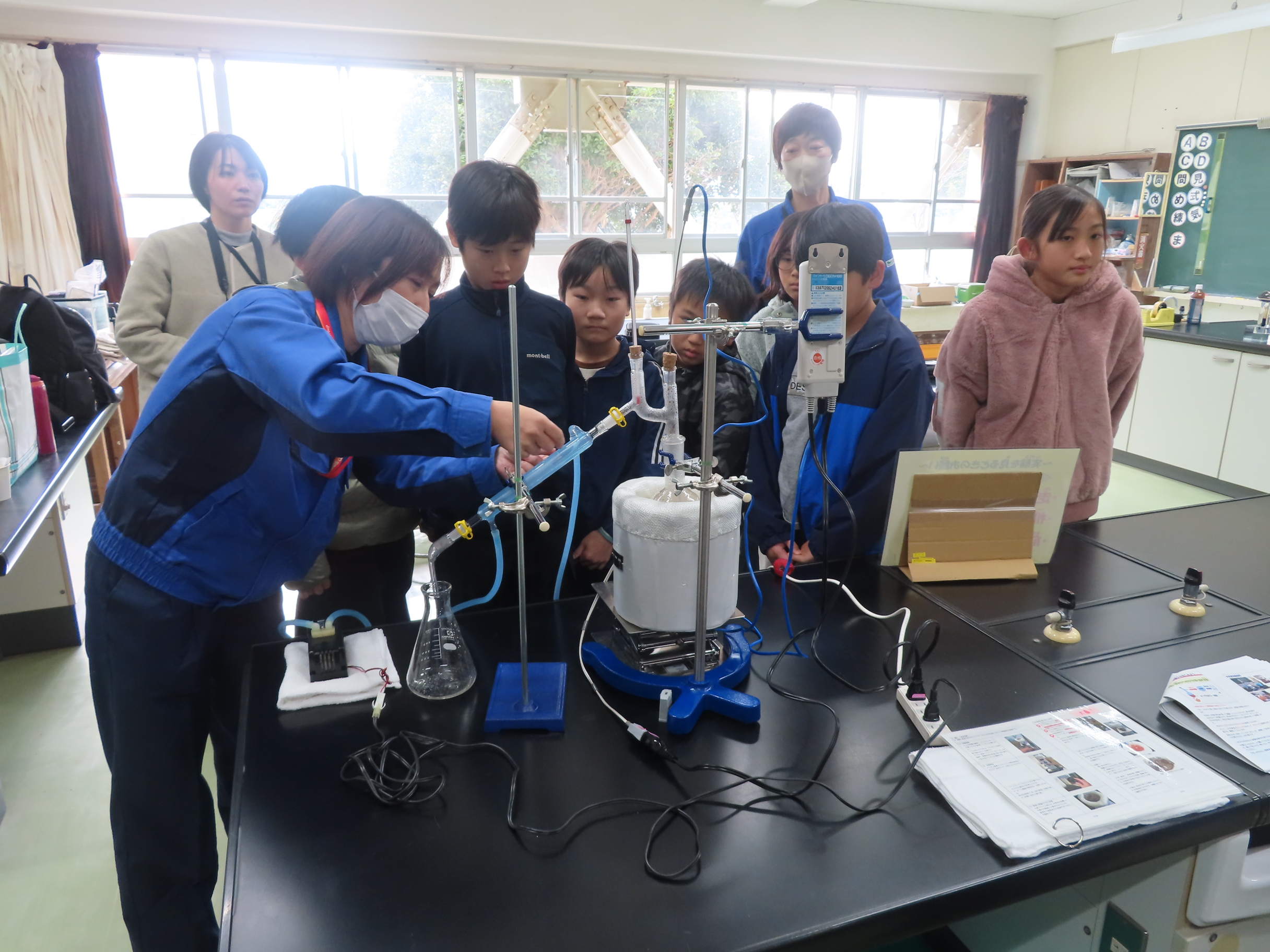 真剣な眼差しで実験方法を観察する児童